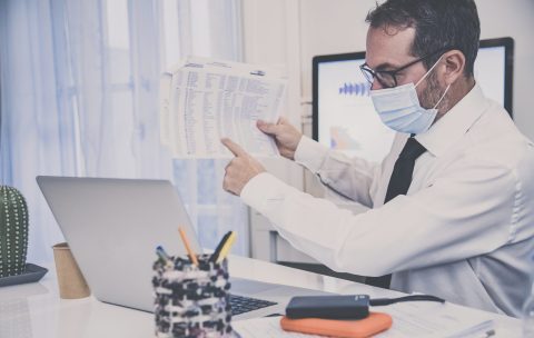 Business man with surgical masks working in the office during lo