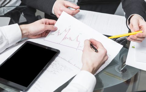 close-up-two-businesspeople-analyzing-report-office