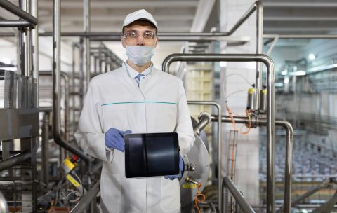 technologist shows a blank screen of the tablet at the dairy plant